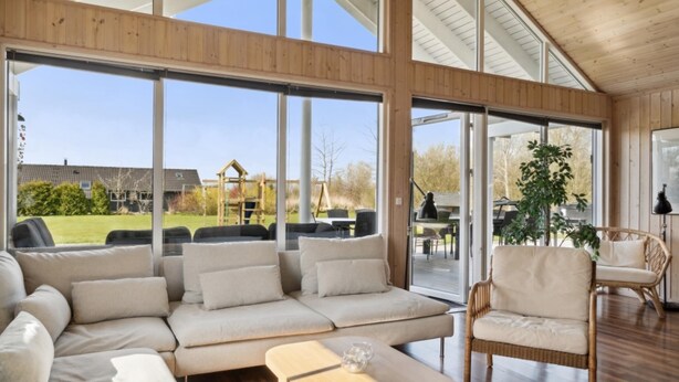 A spacious living area with a large sofa, a wicker chair, and a glass coffee table. - VillaVilla 282 - Marielyst, Lolland/Falster/møn (Idestrup)