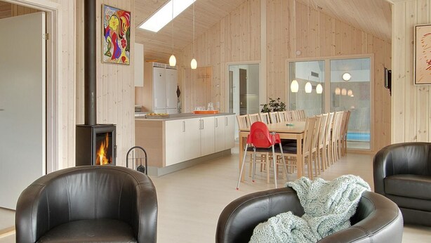 Un intérieur moderne avec des éléments en bois, un coin repas comprenant une table et des chaises, et une cheminée.