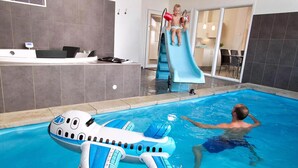 A swimming pool with a slide, a child on the slide, and a man swimming. - VillaVilla 265 - Kegnæs, Sydjylland (Sydals)
