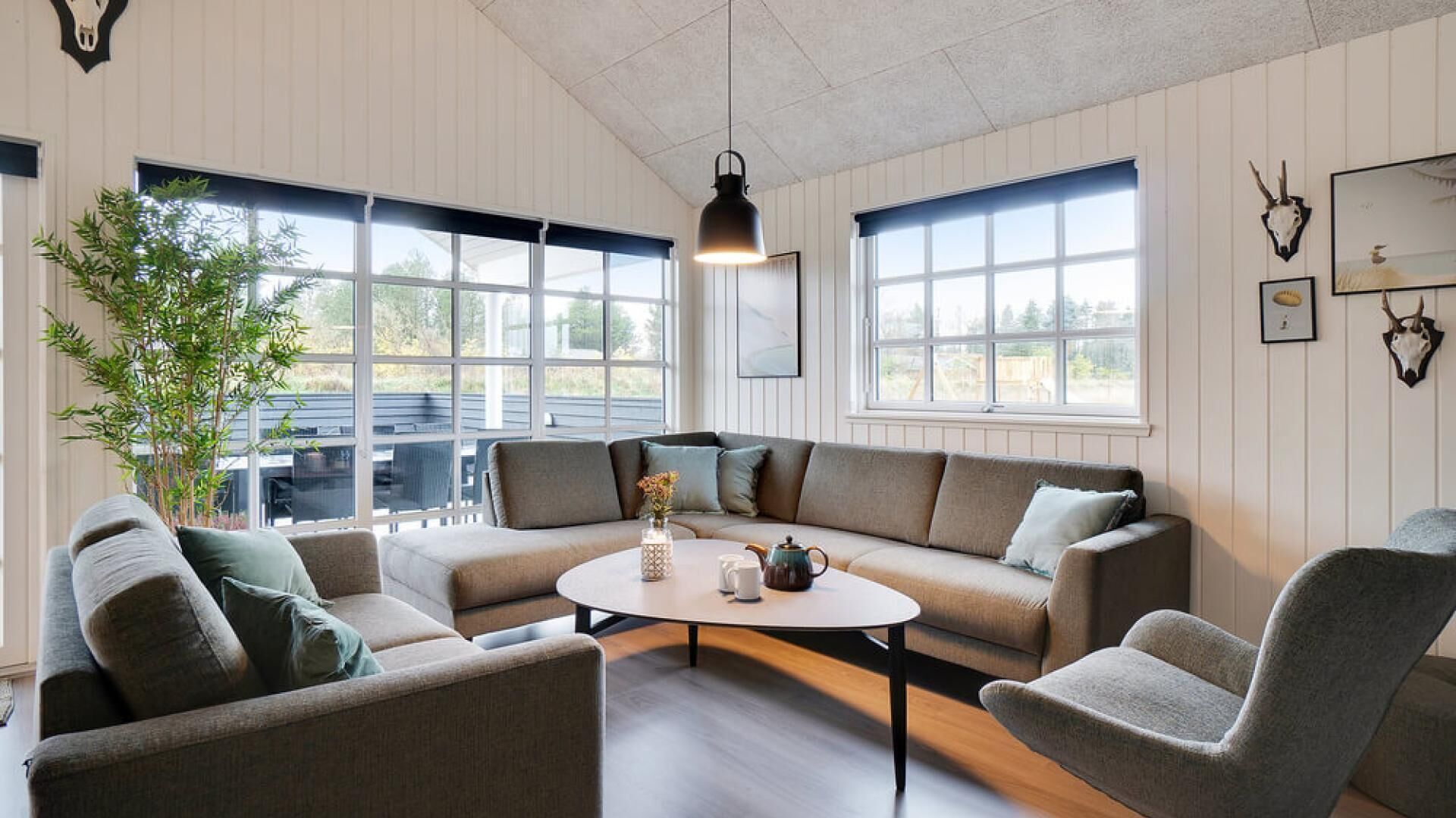 Una sala de estar acogedora con un sofá modular, una mesa redonda y un ventanal con vistas al exterior.