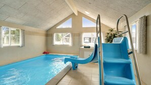 An indoor swimming pool with a blue slide, large windows, and a tiled ceiling. - VillaVilla 451 - Grenå Strand, Østjylland (Grenaa)
