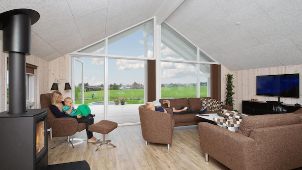 A modern living room with a large window, a fireplace, and a flat-screen TV. - VillaVilla 327 - Faaborg, Fyn og øer (Faaborg)