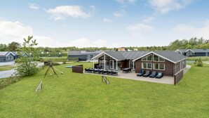 Ein modernes Gebäude mit einer überdachten Terrasse und Sitzgelegenheiten im Freien.