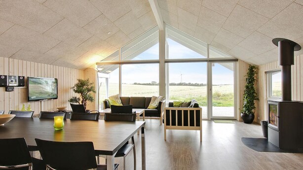 A spacious living area with a large window, a fireplace, and a television mounted on the wall. - VillaVilla 296 - Kegnæs, Sydjylland (Sydals)