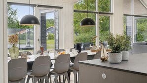 A modern dining area with large windows, a central table, and two pendant lights. - VillaVilla 644 - Østersøbadet, Lolland/Falster/Møn (Rødby)