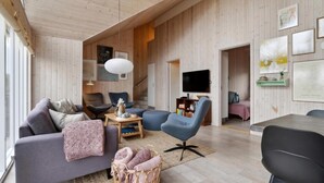 A modern living room with a grey sofa, blue armchairs, and a TV. - VillaVilla 323 - Tisvildeleje, Nordsjælland (Tisvildeleje)