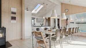 Une cuisine moderne avec un coin repas, des murs en bois et une grande fenêtre.