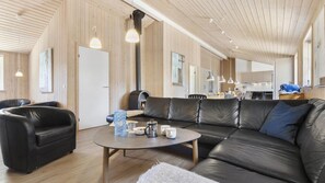 A modern living room with a leather sofa, a round coffee table, and a fireplace. - VillaVilla 247 - Ebeltoft, Østjylland (Ebeltoft)
