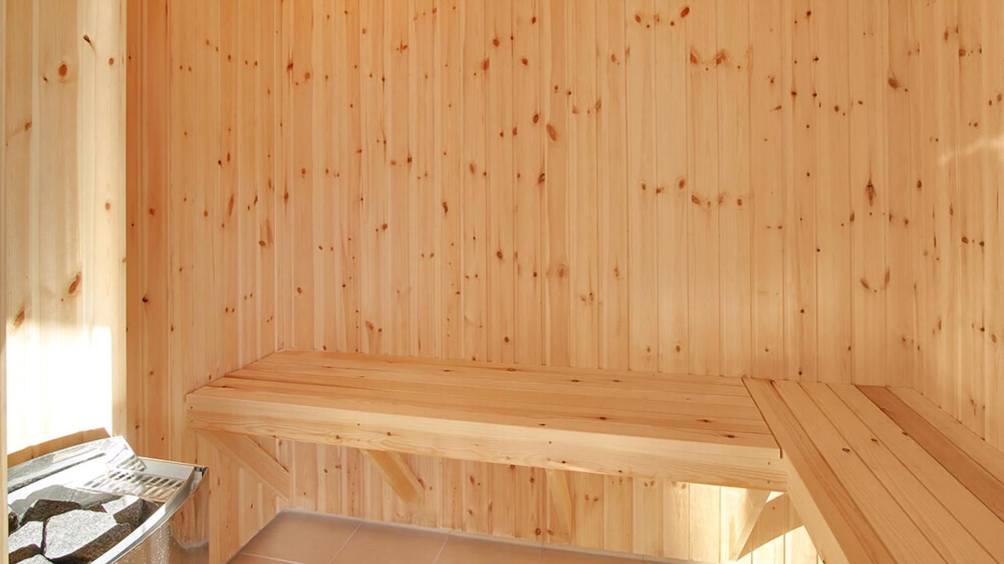 A sauna room with wooden walls and benches.