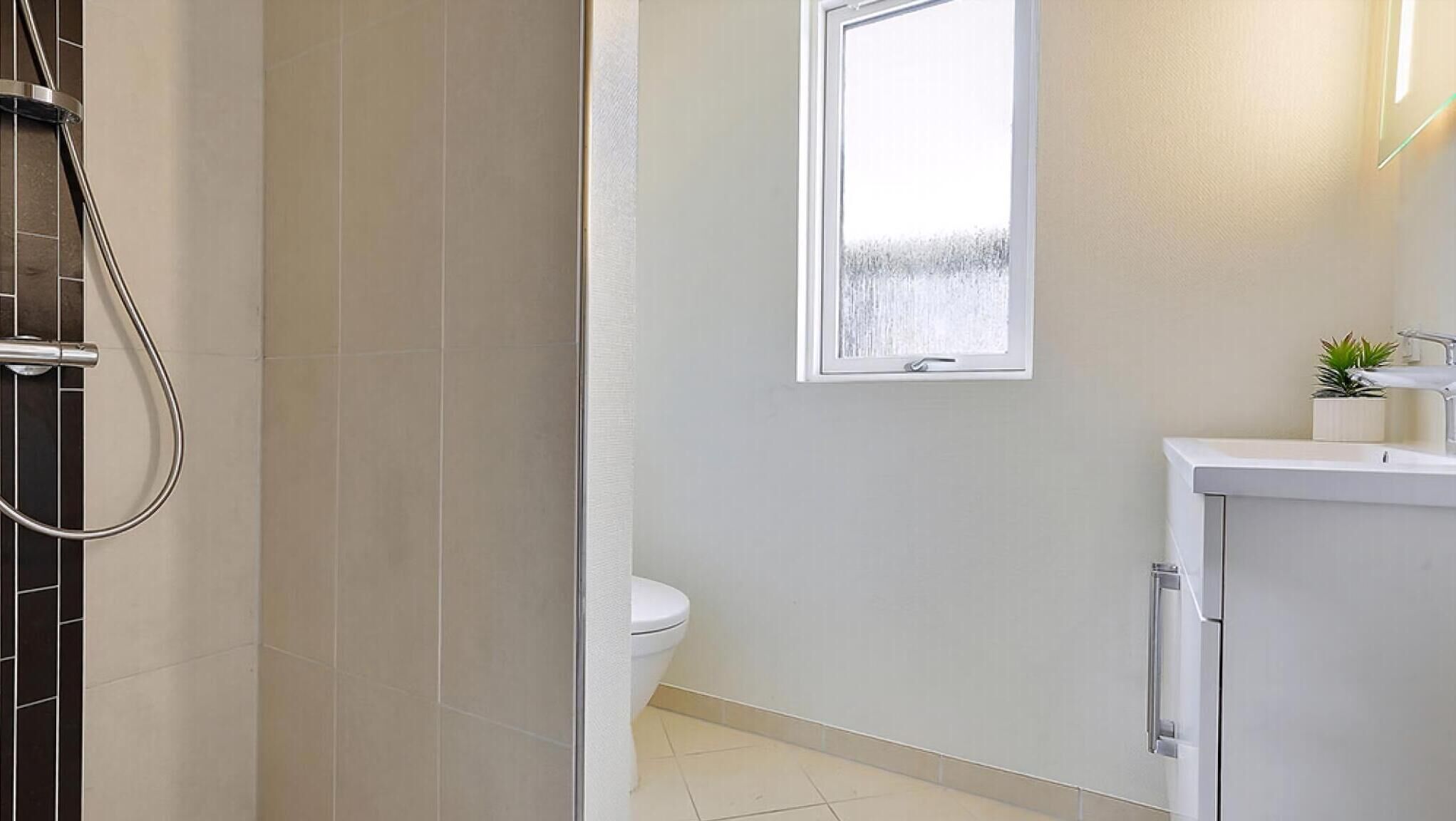 A bathroom with a shower, toilet, and sink.