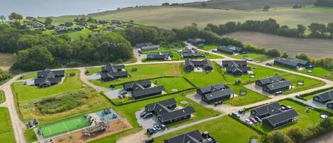 An aerial view of a residential area with houses, a playground, and a sports field.