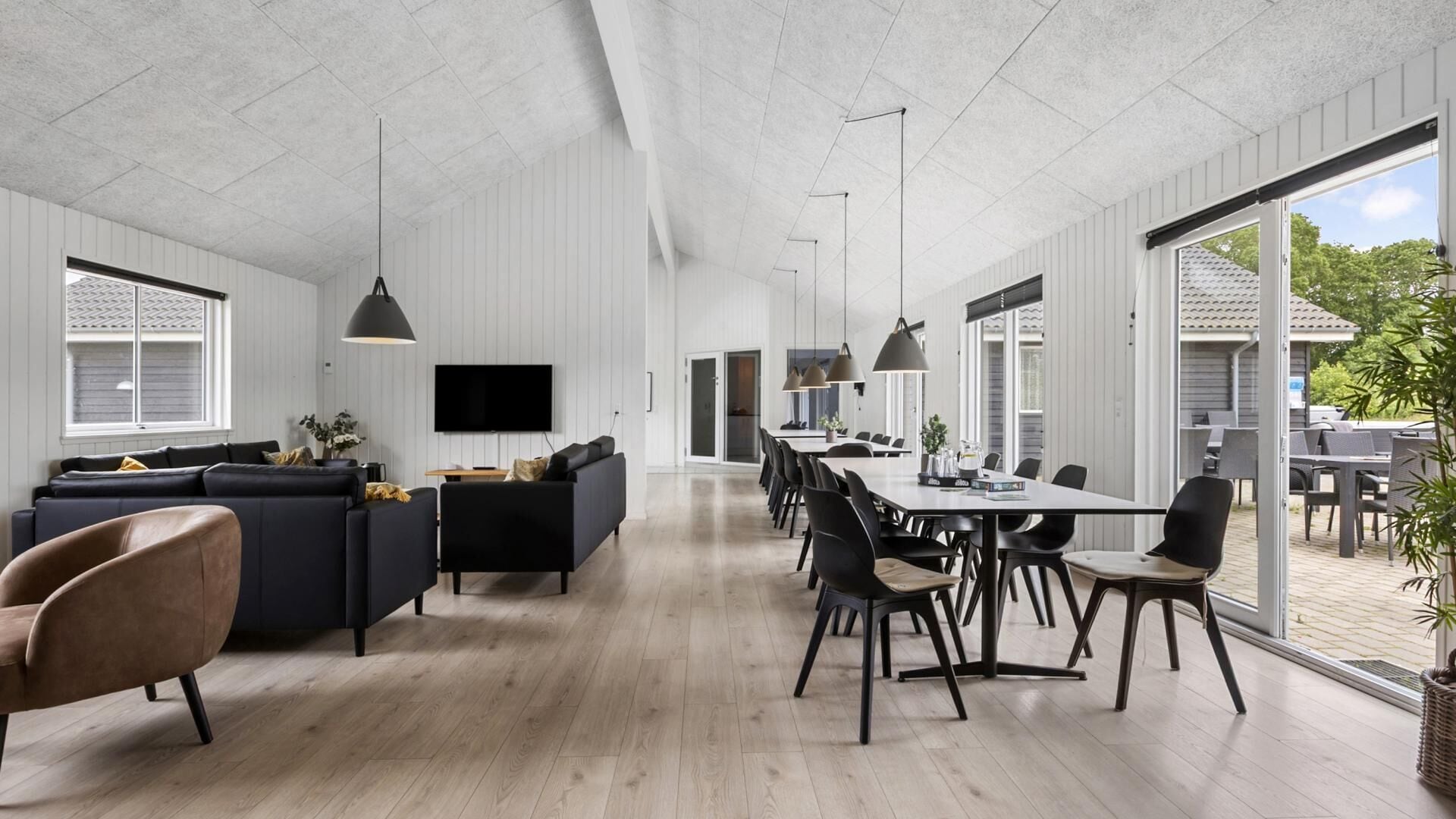 A modern interior with a living area, dining space, and large windows.
