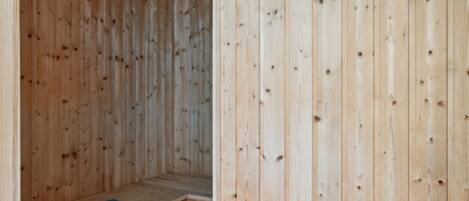 Un sauna en bois, doté d’un banc et d’un revêtement pour le banc.