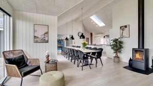 Um interior moderno com área de refeições, lareira e vista para a cozinha.