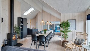 Eine moderne Küche mit Essbereich, Holzwänden und einem sichtbaren Pool.