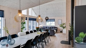 A modern kitchen with a large island, pendant lights, and a view of the outdoors. - VillaVilla 456 - Houstrup Strand, Vestjylland (Nørre Nebel)
