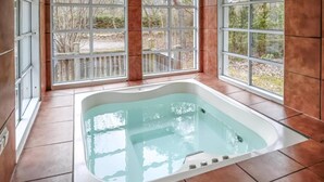 A spa area with a large bathtub, large windows, and a view of the outdoors. - VillaVilla 126 - Öland, Sverige (Köpingsvik)