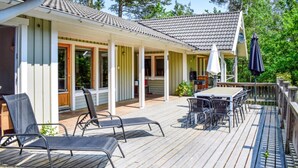 A covered outdoor deck with a table and chairs, a speaker, and a grill. - VillaVilla 126 - Öland, Sverige (Köpingsvik)