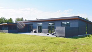 A modern two-story house with a flat roof, large windows, and a covered patio area. - VillaVilla 908 - Marielyst, Lolland/Falster/møn (Væggerløse)