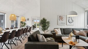 Ett modernt hotellrum med en matplats, en soffa och ett soffbord.