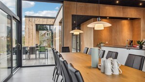 A modern dining area with a wooden table, black chairs, and pendant lighting. - VillaVilla 684 - Virksund, Limfjorden (Højslev)