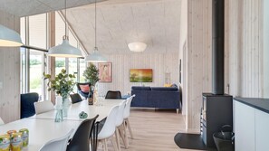 Eine moderne Küche mit Essbereich, Holzwänden und einem großen Fenster.