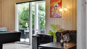 Ett mysigt rum med ett biljardbord, en lädersoffa och ett bord med en vinflaska och glas.