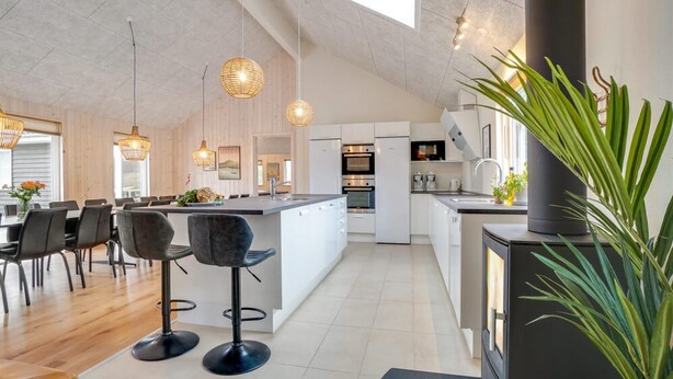 A modern kitchen with a central island, bar stools, pendant lighting, and a large potted plant. - VillaVilla 474 - Grenå Strand, Østjylland (Grenaa)