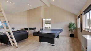 A room with a ping pong table, a sofa, a ladder, and a large window. - VillaVilla 399 - Blåvand, Vestjylland (Blåvand)