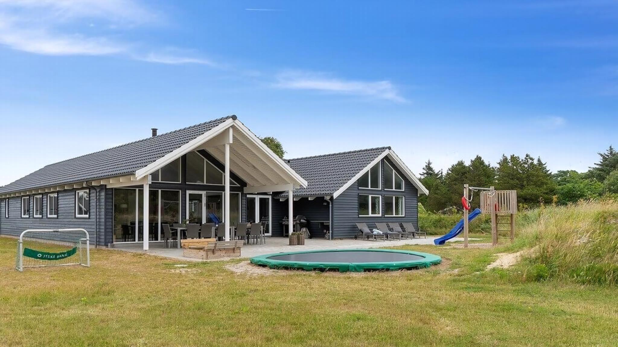 Un bâtiment à deux étages doté d’un patio couvert, d’une piscine et d’une aire de jeux.