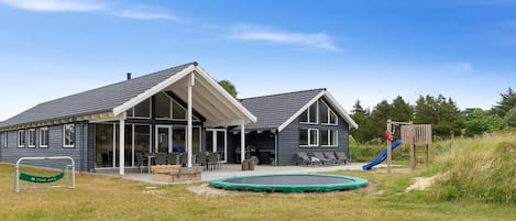 A two-story building with a covered patio, a swimming pool, and a playground.
