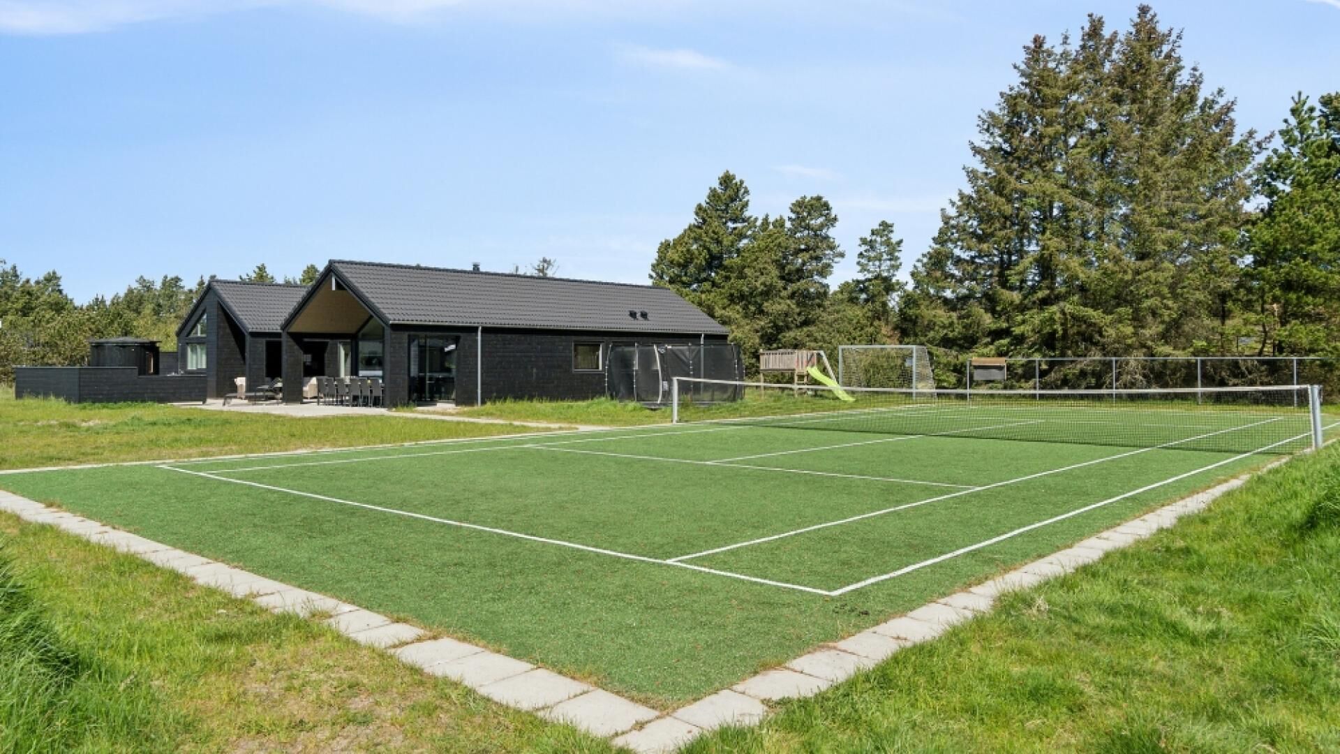 A sports field with a goalpost and a building with a sloped roof.