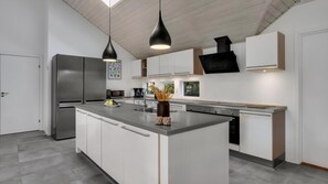 A modern kitchen with a central island, stainless steel appliances, and pendant lighting. - VillaVilla 571 - Rømø, Sydjylland (Rømø)
