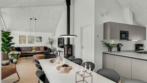 Een moderne woonruimte met een eethoek, keuken en een groot raam.