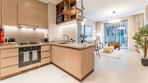 Une cuisine moderne dotée d’appareils électroménagers intégrés, d’un îlot central et d’un coin repas comprenant un canapé et une table.