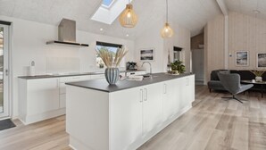 A modern kitchen with a central island, white cabinetry, and pendant lighting. - VillaVilla 594 - Rømø, Sydjylland (Rømø)