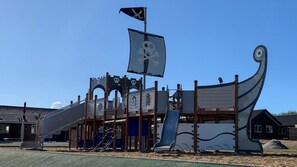 Une structure de jeux sur le thème des pirates, dotée de toboggans, d’aires d’escalade et conçue pour ressembler à un navire.