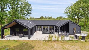 A modern cabin with a patio area, large windows, and a covered outdoor seating space. - VillaVilla 627 - Henne Strand, Vestjylland (Henne)