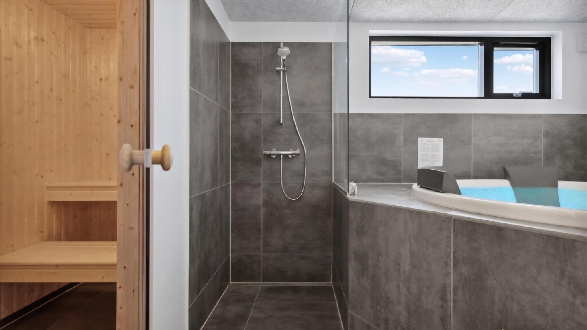 Ein modernes Badezimmer mit Dusche, Badewanne und Fenster.