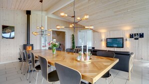 A modern dining area with a wooden table, black chairs, and a chandelier. - VillaVilla 264 - Kegnæs, Sydjylland (Sydals)