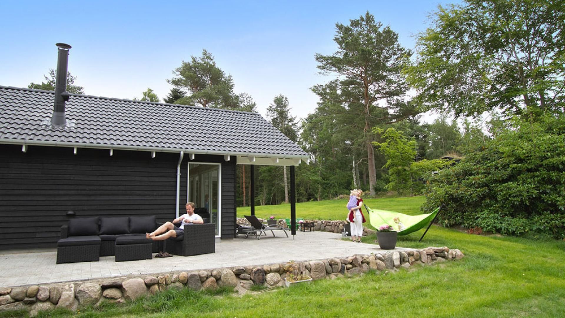 A house with a patio, outdoor seating, and a covered area.
