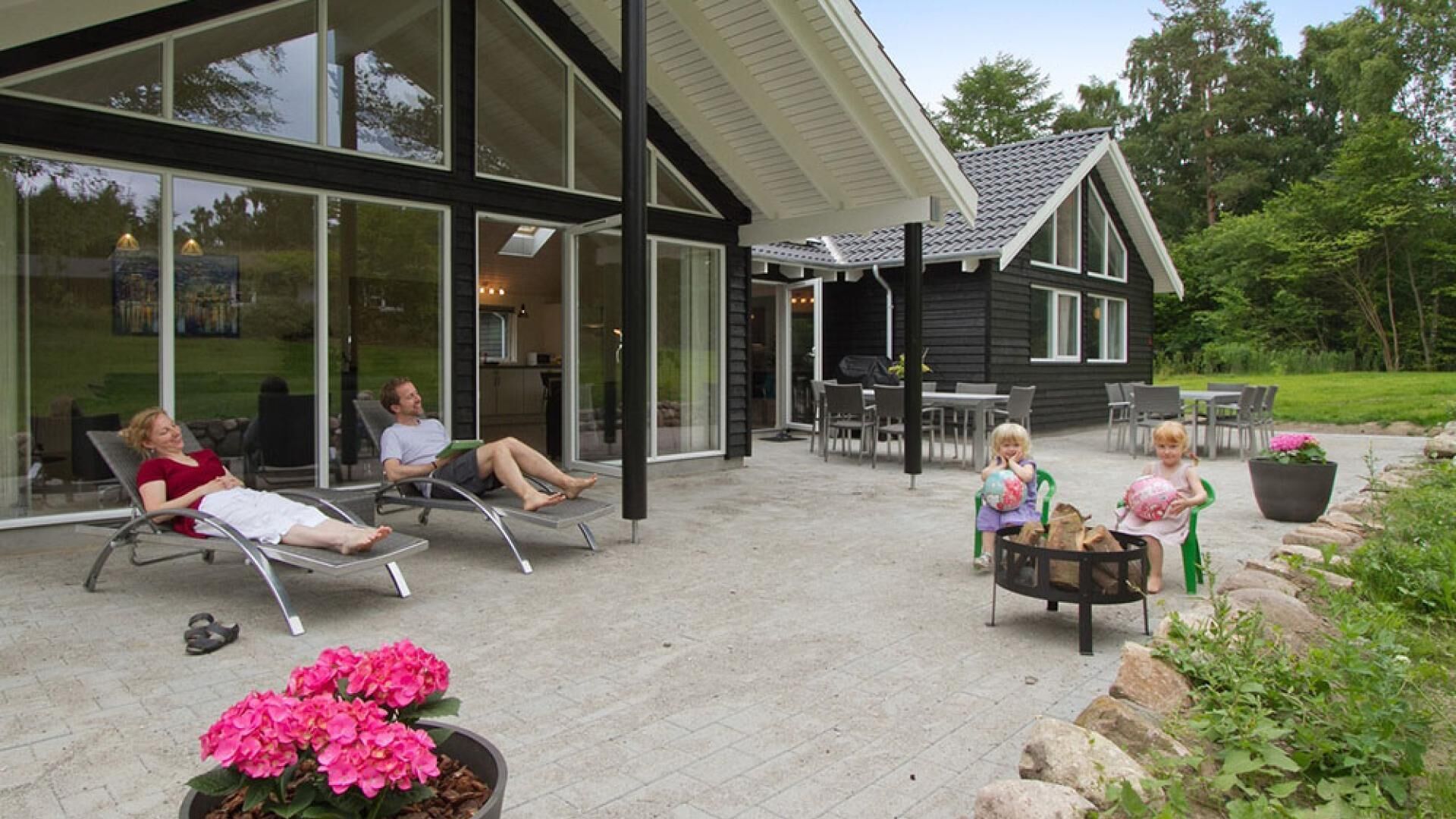 A covered patio with lounge chairs, a dining area, and a garden with potted plants.