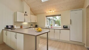 Una cocina moderna con una isla central, horno empotrado y ventana que proporciona luz natural.