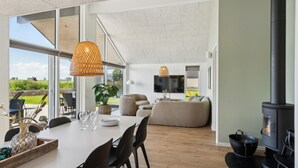 A spacious living area with a dining table, sofas, and a fireplace. - VillaVilla 618 - Hasmark Strand, Fyn og øer (Otterup)