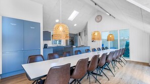 A modern kitchen with blue cabinets, a large island, and pendant lighting. - VillaVilla 332 - Søndervig, Vestjylland (Ringkøbing)
