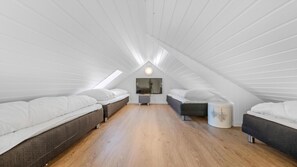 A modern attic bedroom with two beds, a large mirror, and a wooden floor. - VillaVilla 332 - Søndervig, Vestjylland (Ringkøbing)