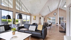 A spacious living area with a large sofa, dining table, and kitchen area. - VillaVilla 315 - Skåstrup Strand, Fyn og øer (Bogense)