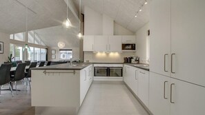 A modern kitchen with white cabinetry, a central island, and pendant lighting. - VillaVilla 409 - Blåvand, Vestjylland (Blåvand)