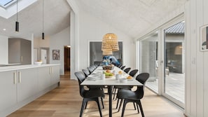 A modern kitchen with a long dining table, black chairs, and a unique woven light fixture. - VillaVilla 665 - Hasmark Strand, Fyn og øer (Otterup)