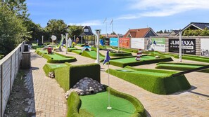 A miniature golf course with green hedges, a flag, and a flagpole. - VillaVilla 665 - Hasmark Strand, Fyn og øer (Otterup)